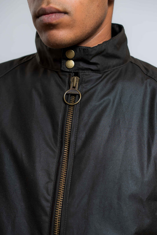 dettaglio della chiusura frontale con zip del giubbino merchant waxed verde di barbour international