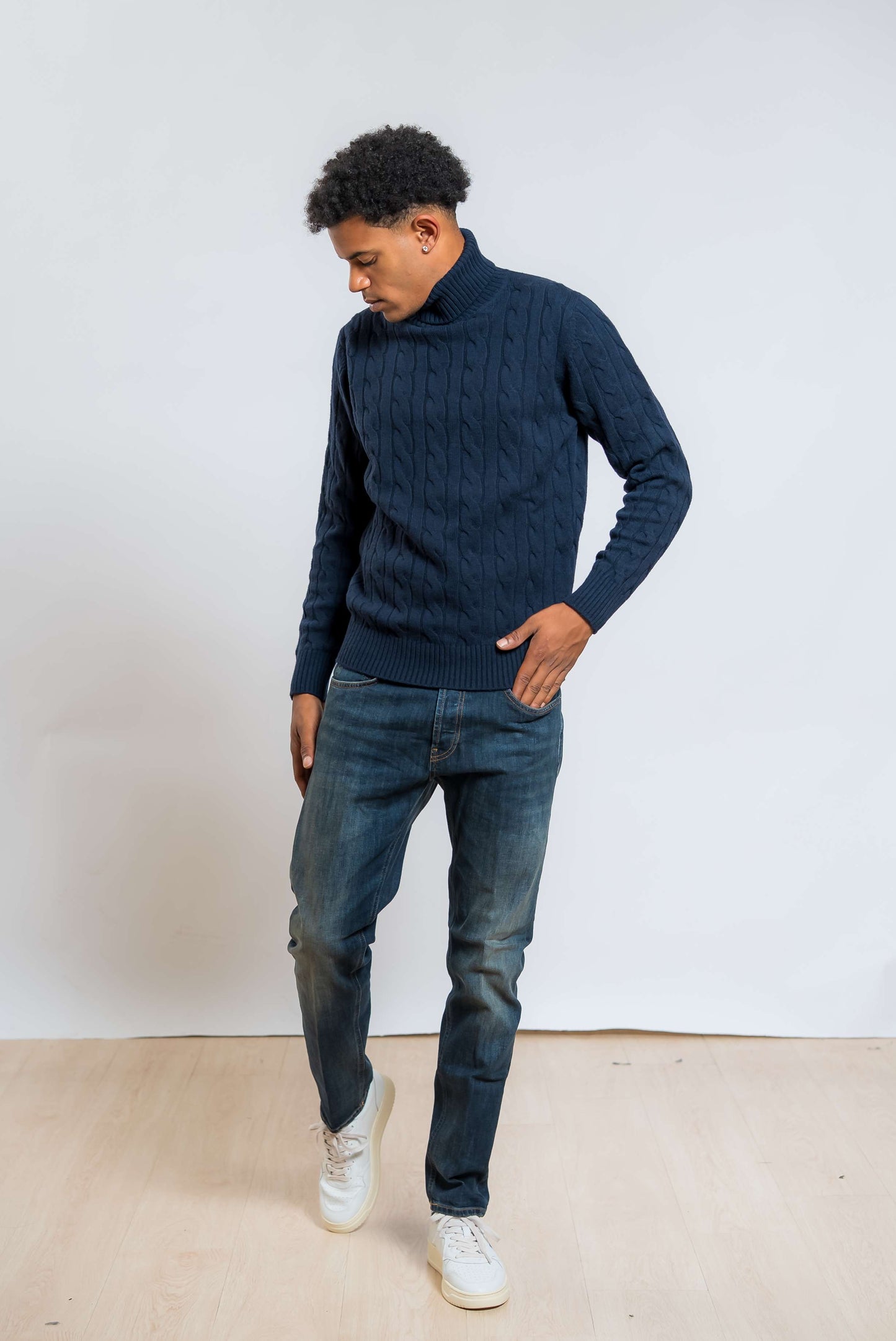 maglione a collo alto in lana blu con lavorazione a trecce di kangra abbinato ad un jeans blu