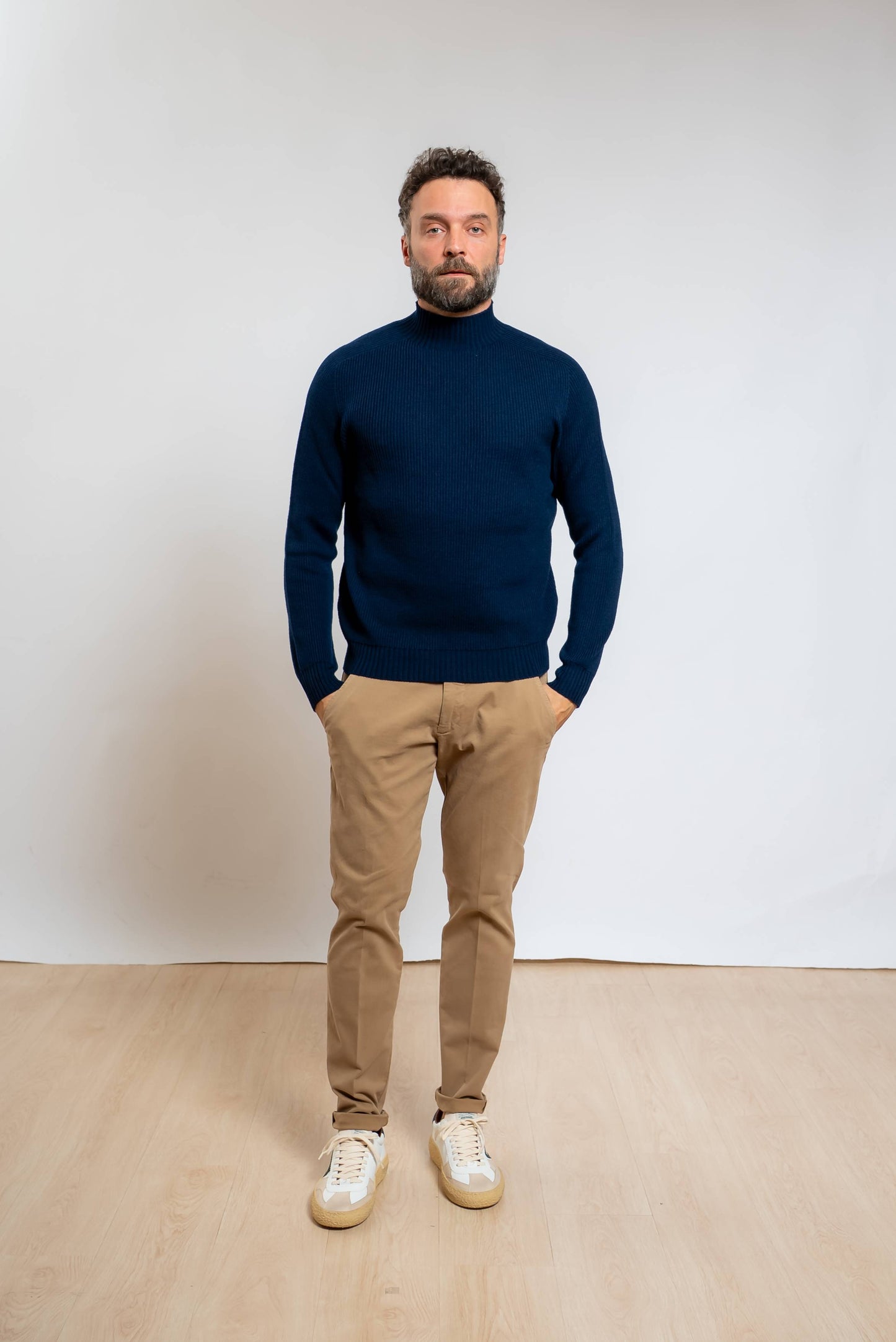 amaranto maglione a costine in lana blu con collo in piedi in pura lana abbinato ad un pantalone beige e sneakers bianche