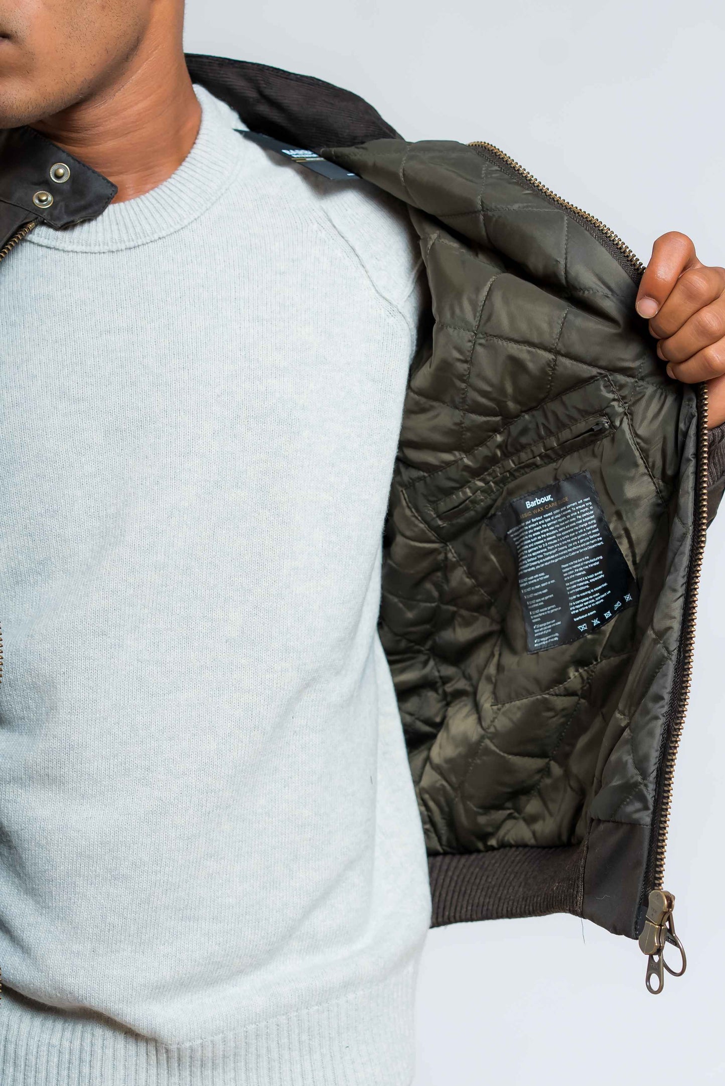 dettaglio taschino interno e trapunta del giubbino merchant waxed verde di  barbour international