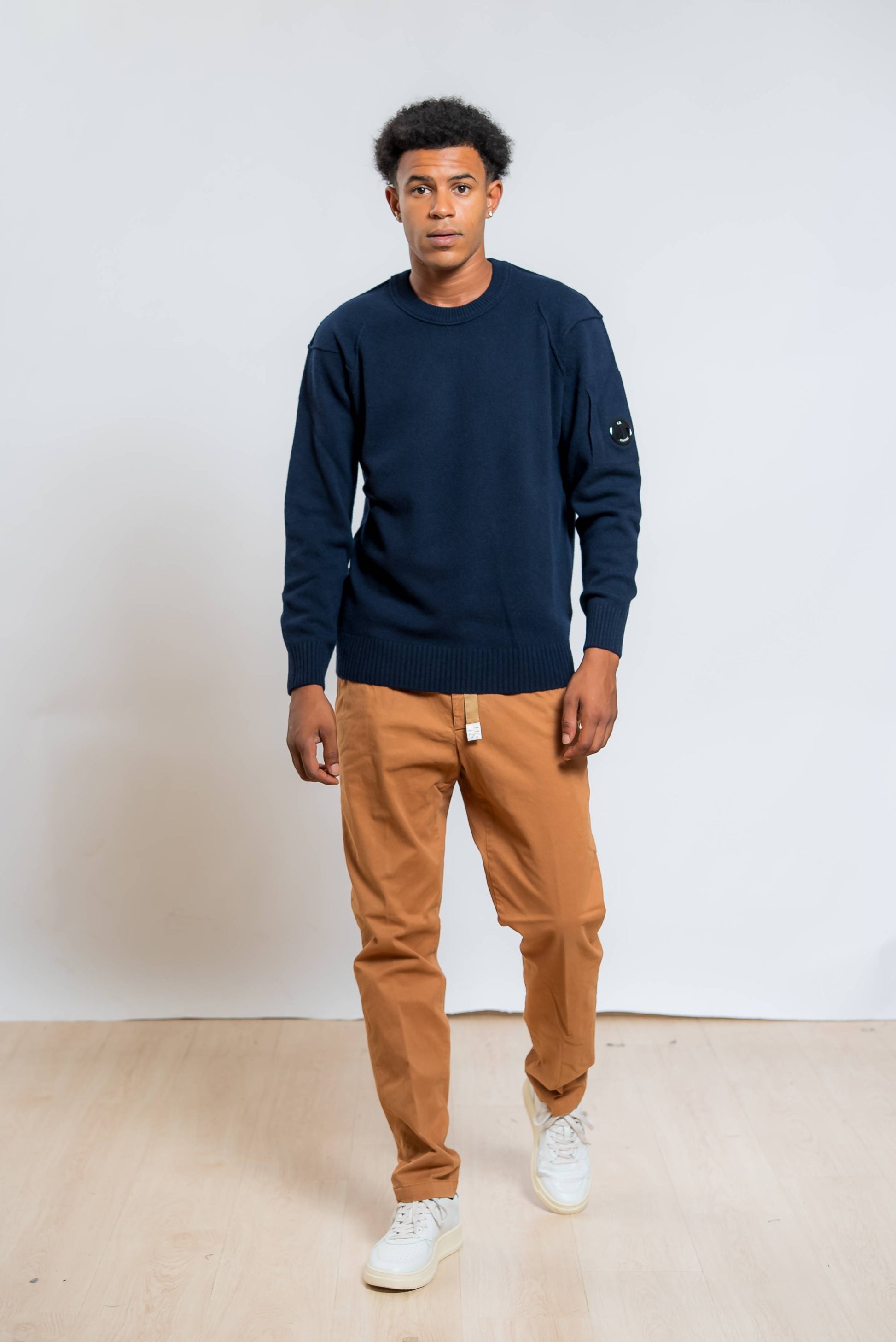 cp company maglione lambswool in lana blu abbinato ad un pantalone marrone chiaro