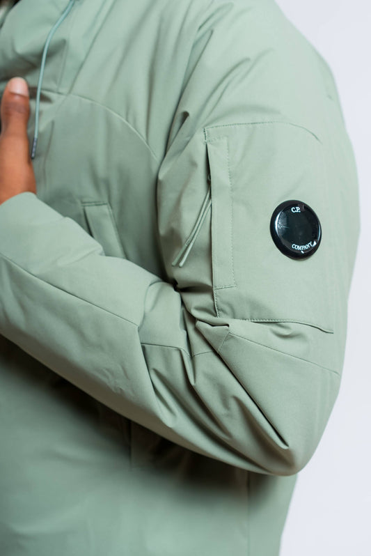dettaglio del taschino sulla manica con lente cp company sul giubbino pro tek medium verde con cappuccio