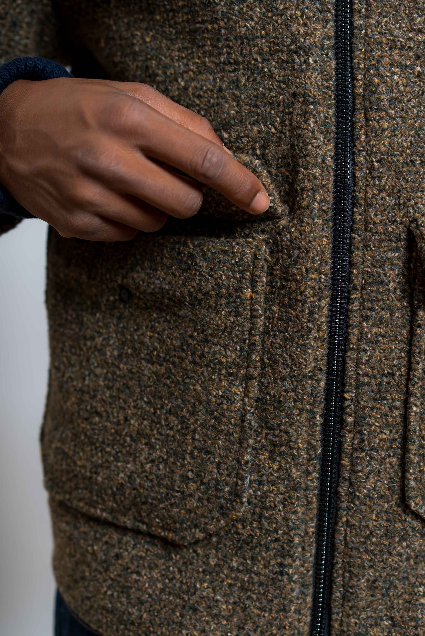 dettaglio tasca frontale del bomber paul verde con cappuccio in pelliccia beige di bob