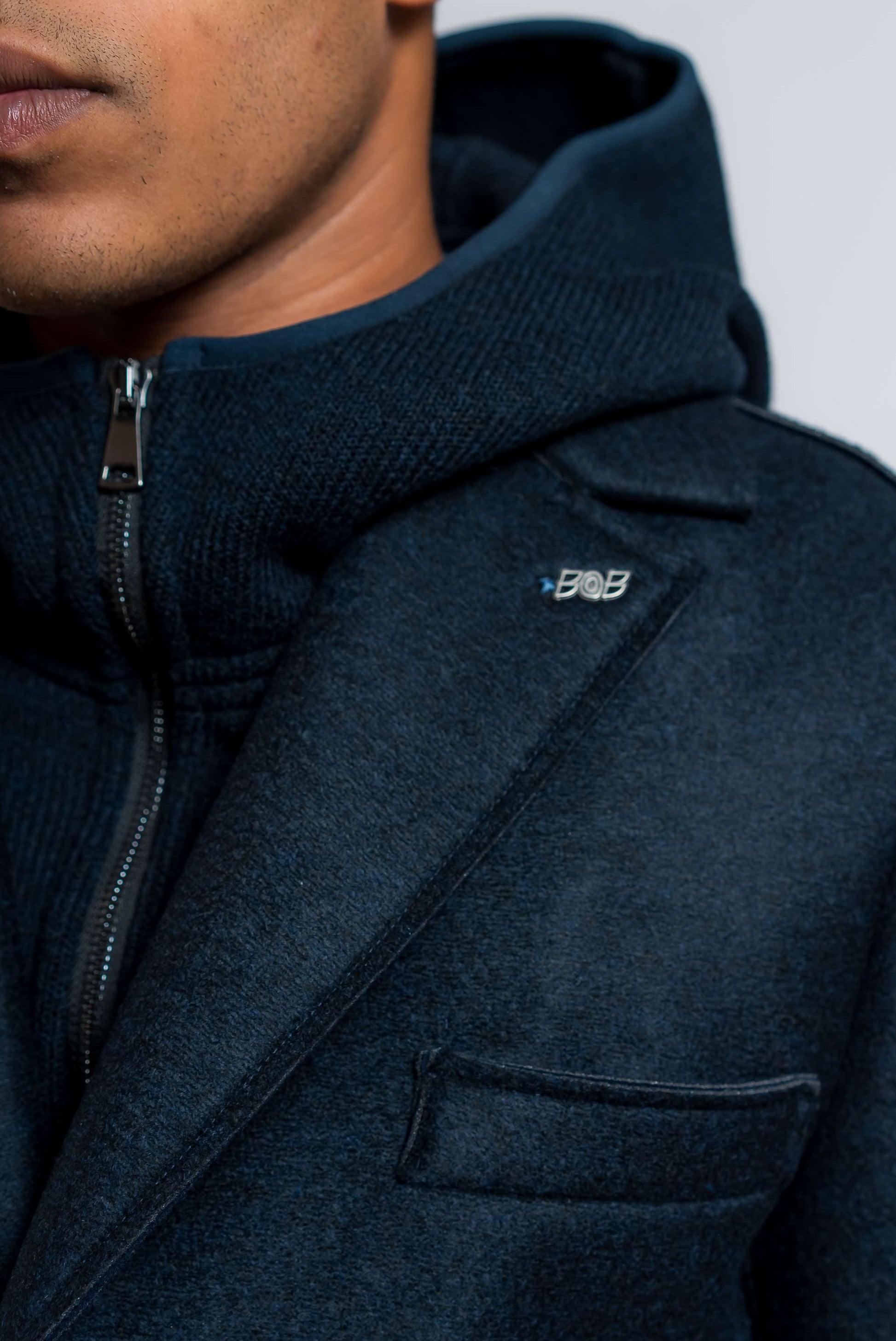 dettaglio del cappuccio in maglia sul cappotto monopetto in neoprene blu di bob 