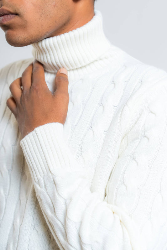 dettaglio del collo alto e polsino lavorato a coste sul maglione a trecce in lana panna di kangra