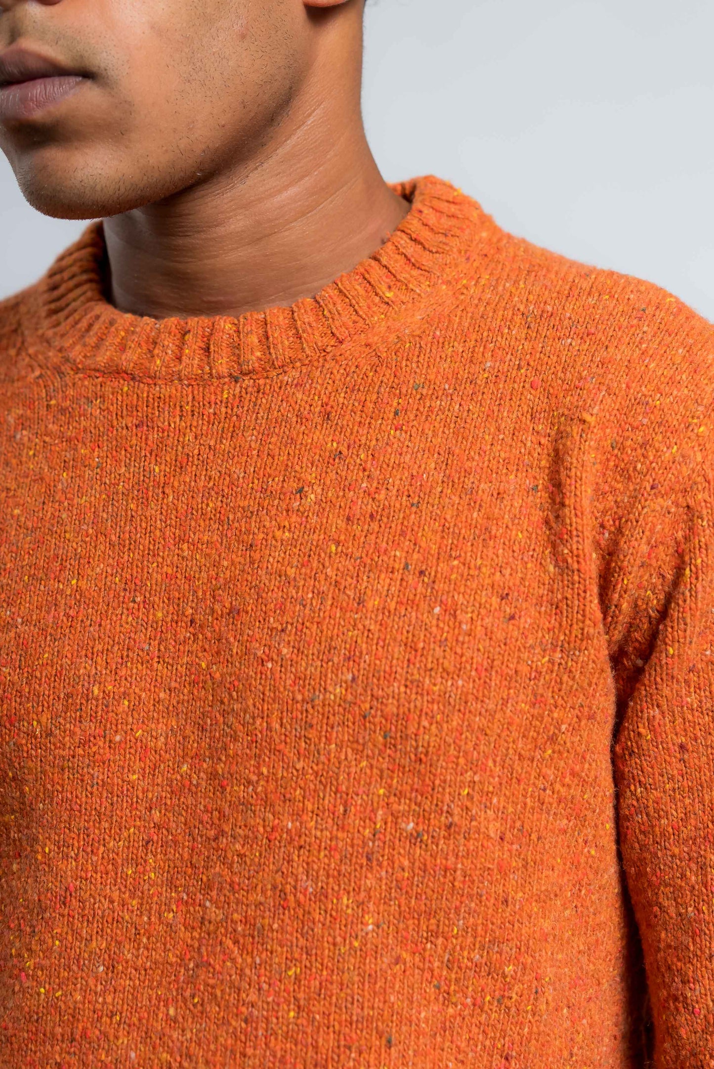 dettaglio del girocollo a coste sul maglione in lana boucle arancione di kangra