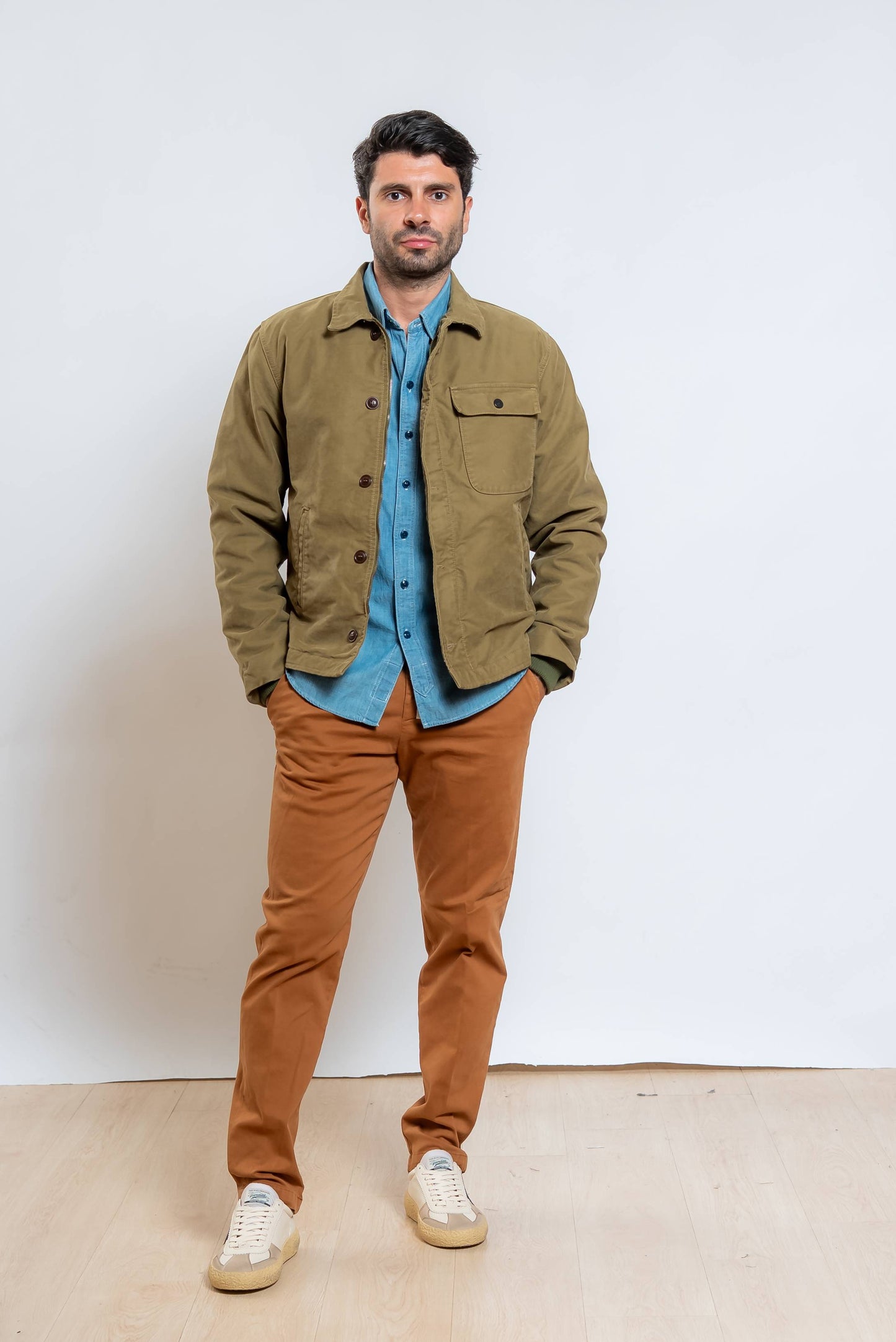 giubbino a2 deck verde di chesapeak's abbinato ad una camicia in denim blu e un pantalone marrone