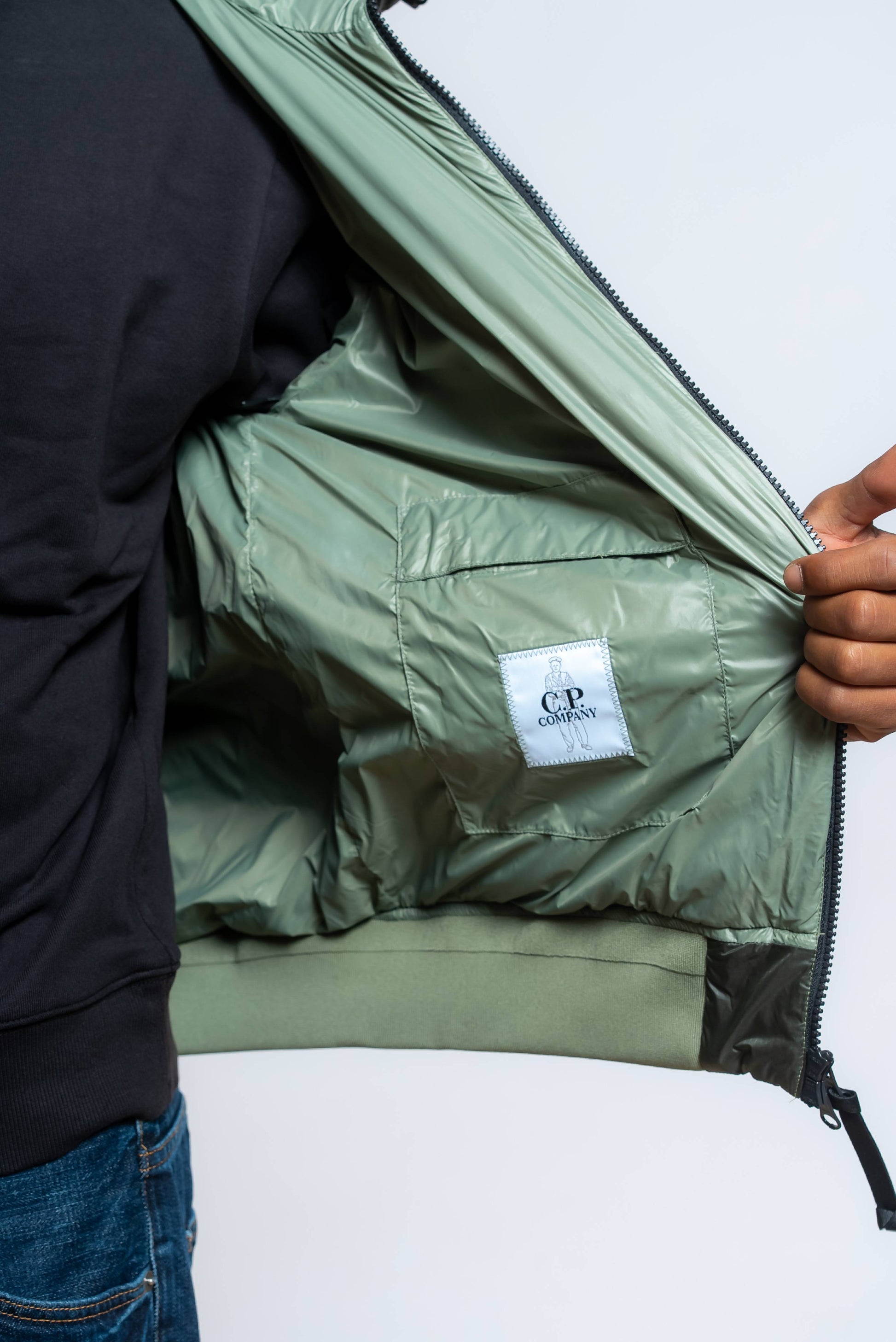 dettaglio del taschino interno del piumino dd shell verde con etichetta cp company 