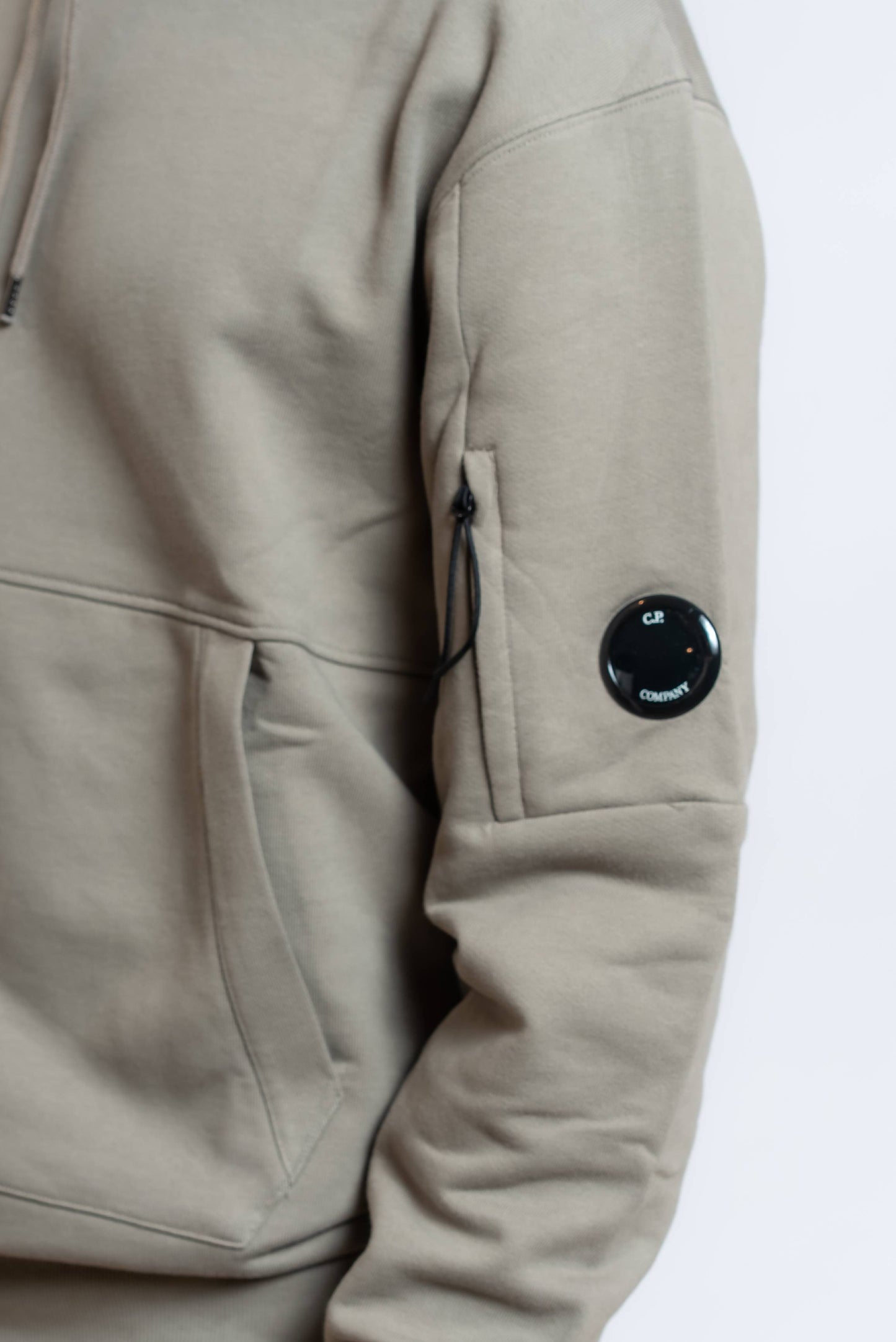 dettaglio del taschino con Lens cp company sulla felpa hooded diagonal raised fleece in cotone verde con cappuccio