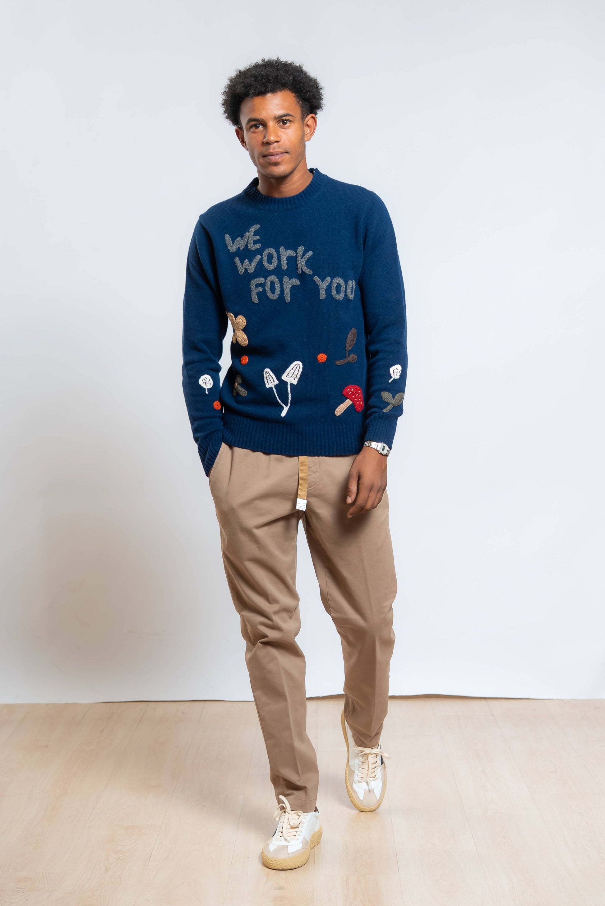 Look completo del maglione bond di bob in lana blu, abbinato a pantalone beige e sneakers bianca