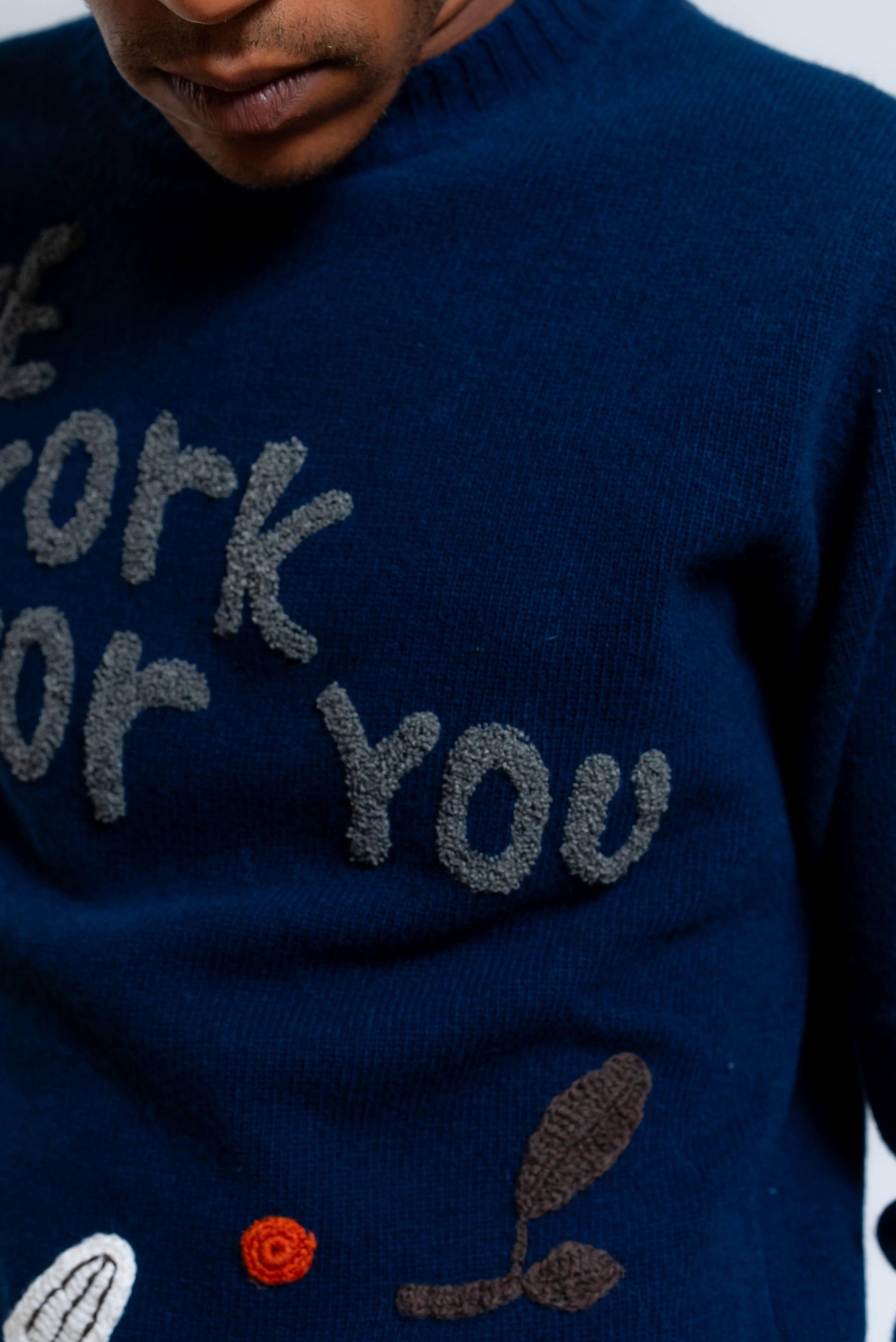 Dettaglio del maglioncino modello bond di bob company in lana blu con ricami realizzati a mano 