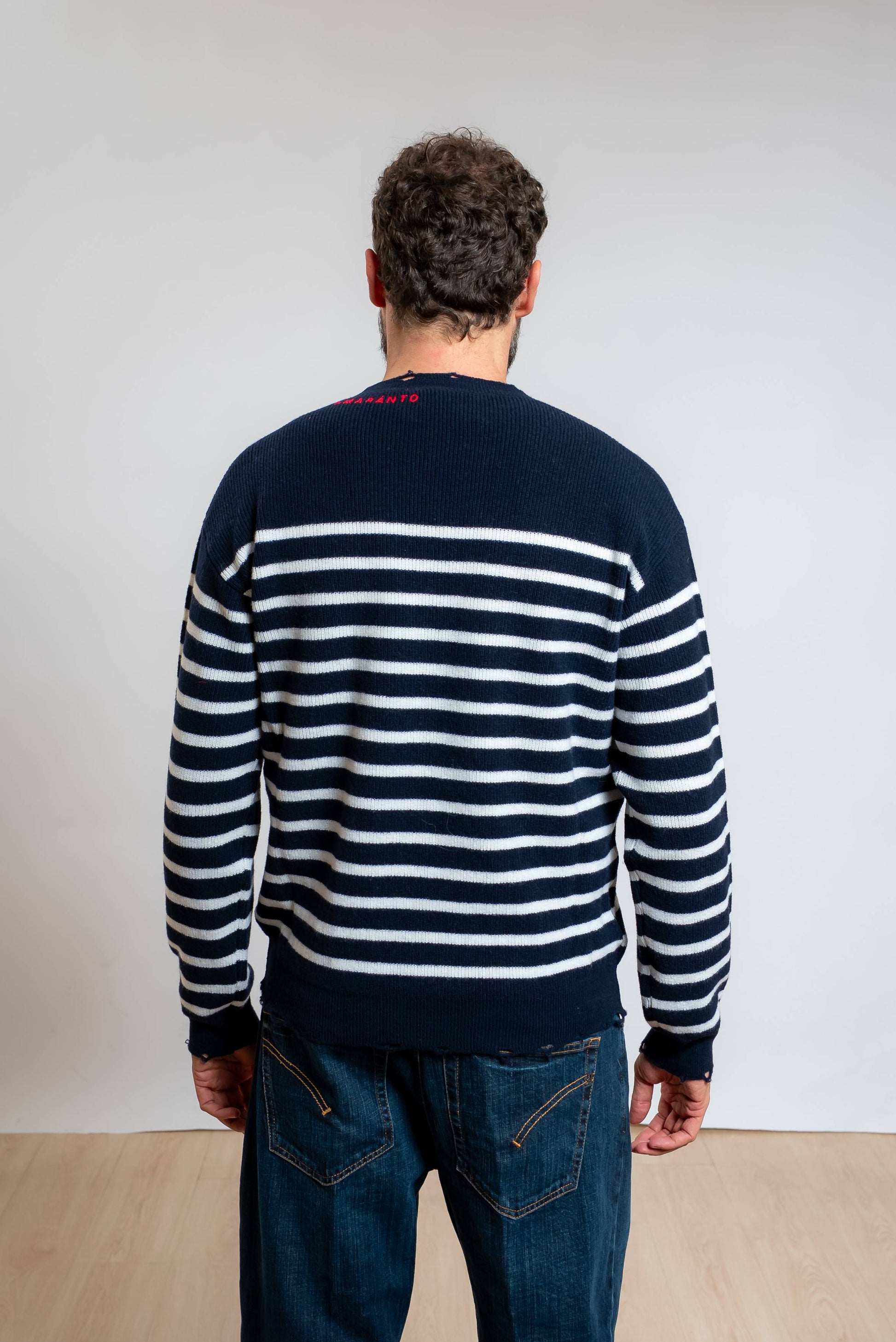 amaranto maglia da uomo in pura lana blu con righe bianche e rotture sugli orli con logo ricamato in rosso, vista posteriore