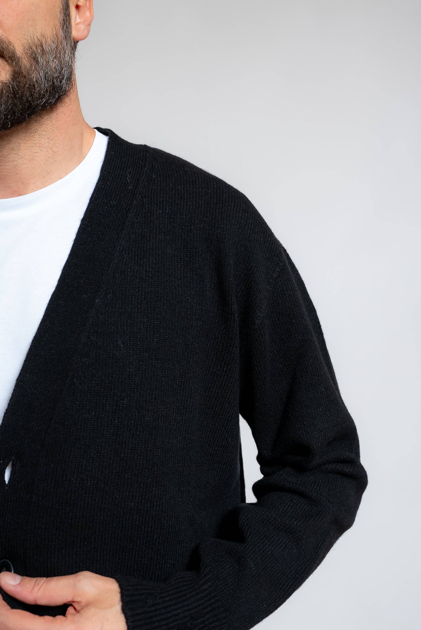 dettaglio delle rotture sugli orli sul cardigan in lana e cashmere nero di amaranto