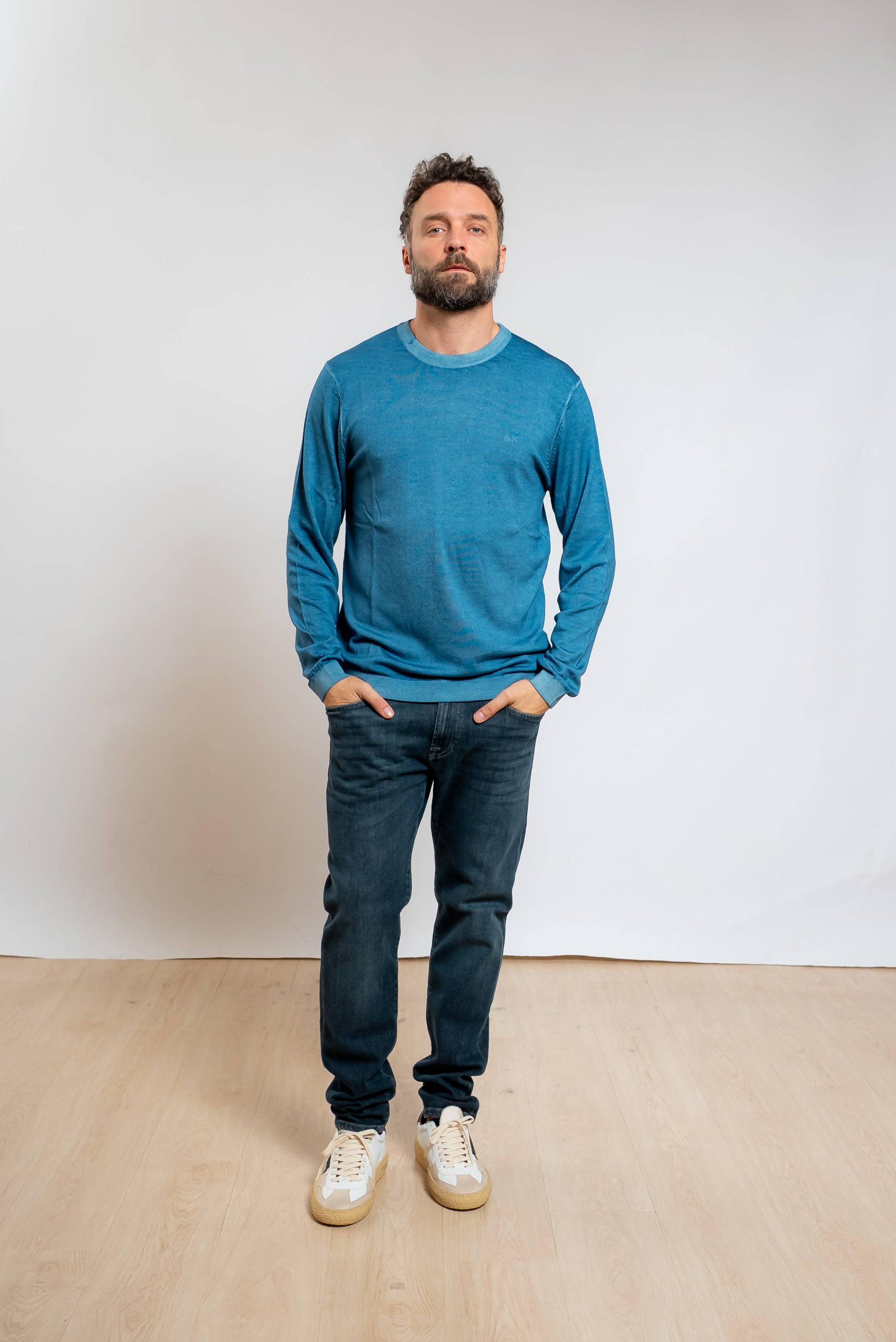 sun68 uomo maglia a girocollo in lana merino azzurra con effetto vintage abbinata ad un jeans blu scuro e sneakers bianche