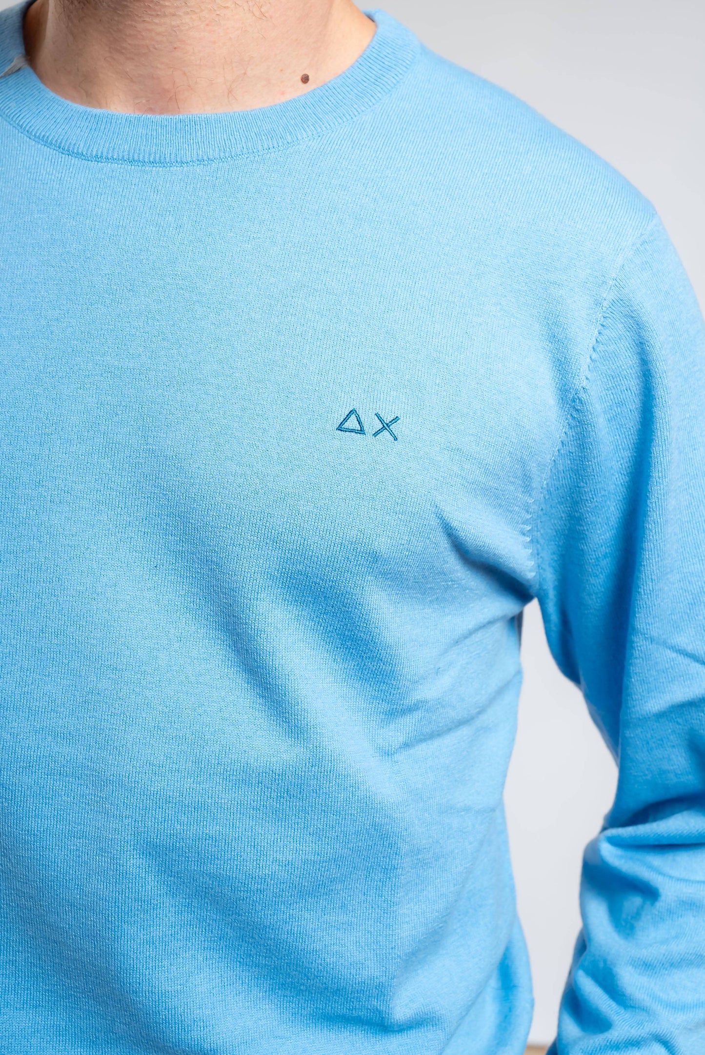 dettaglio del logo sun68 ricamato sulla maglia da uomo celeste basic in lana merino e cotone 