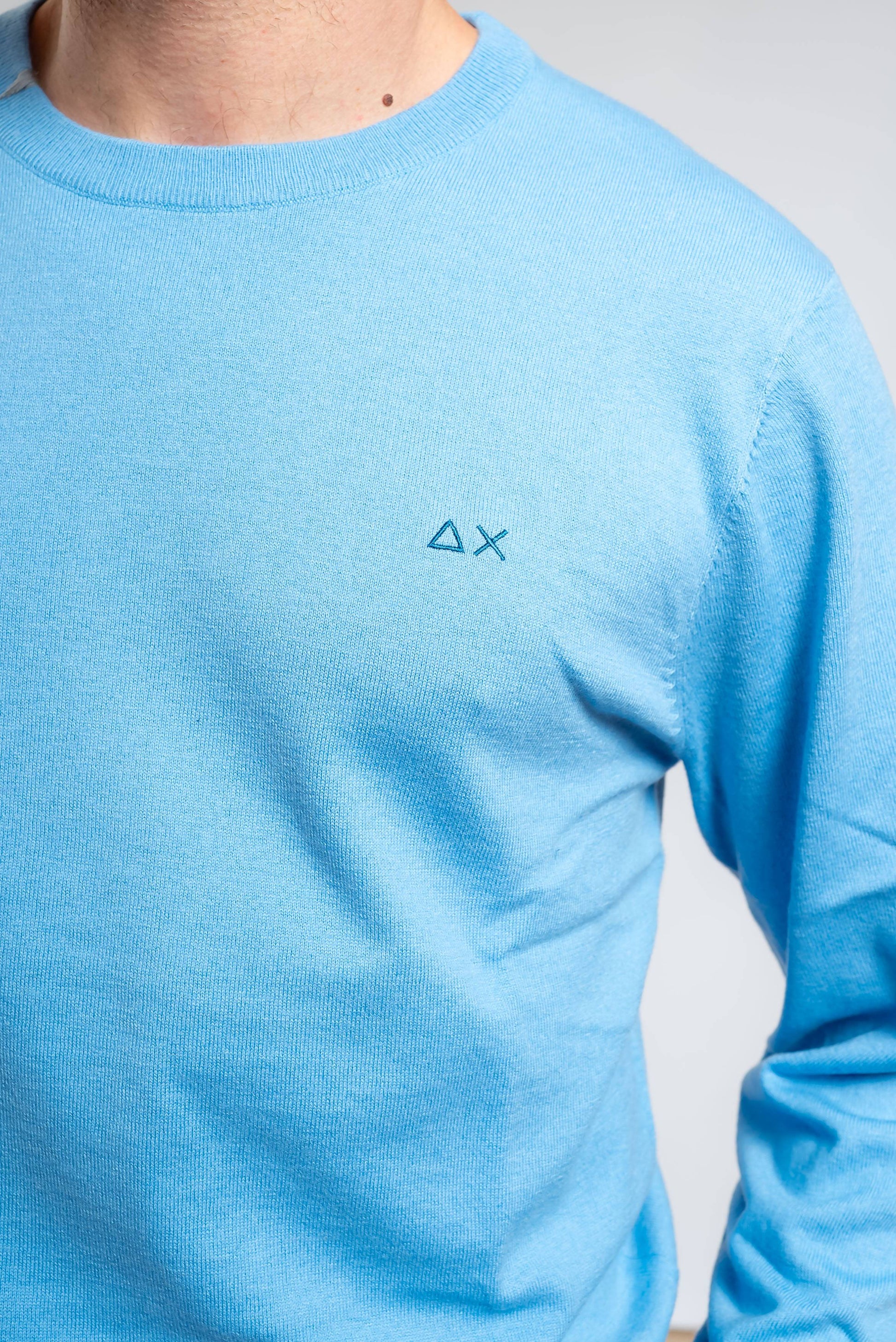dettaglio del logo sun68 ricamato sulla maglia da uomo celeste basic in lana merino e cotone 