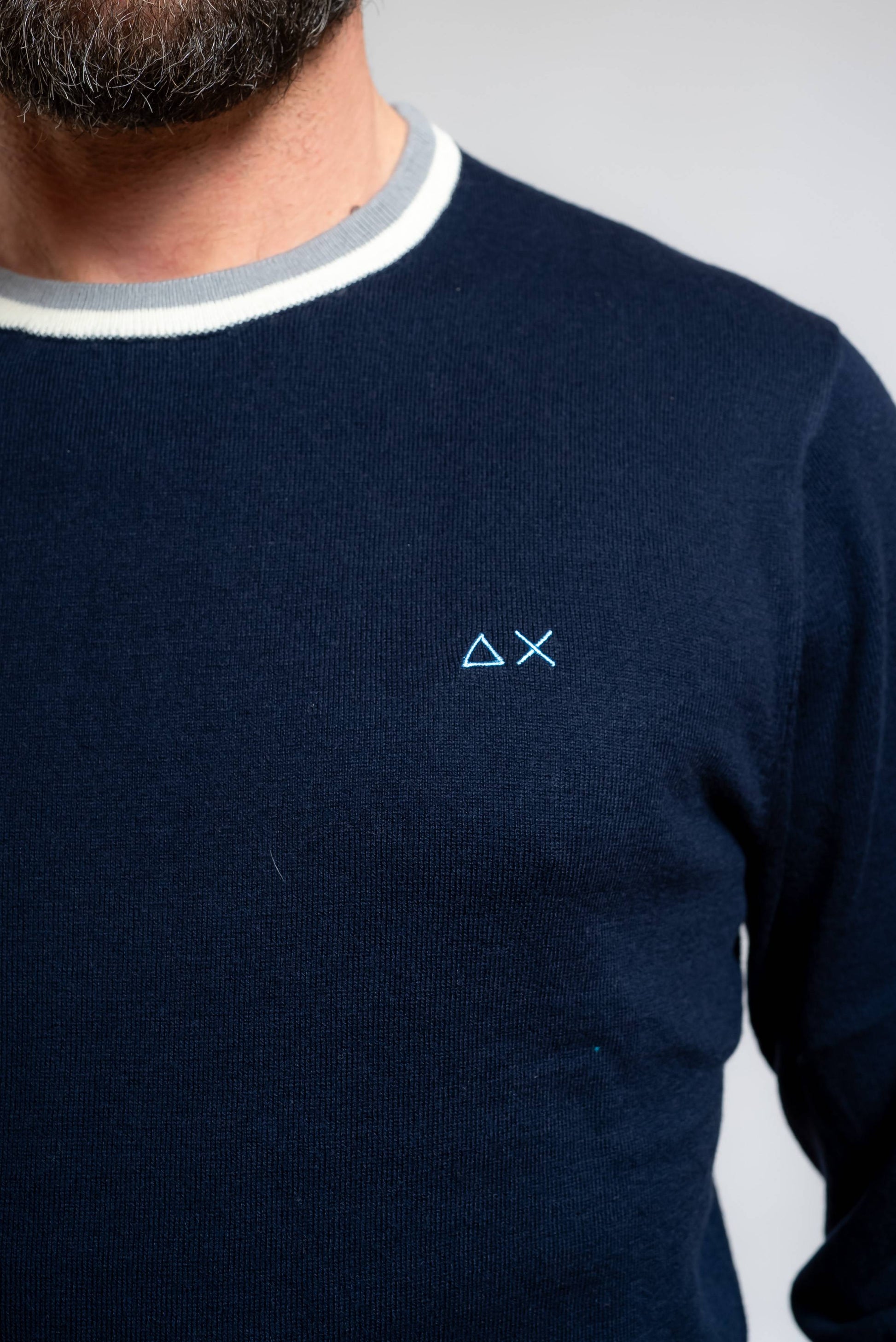 dettaglio del girocollo a righe e del logo sun68 ricamato sul petto sulla maglia stripes da uomo blu navy in lana e cotone