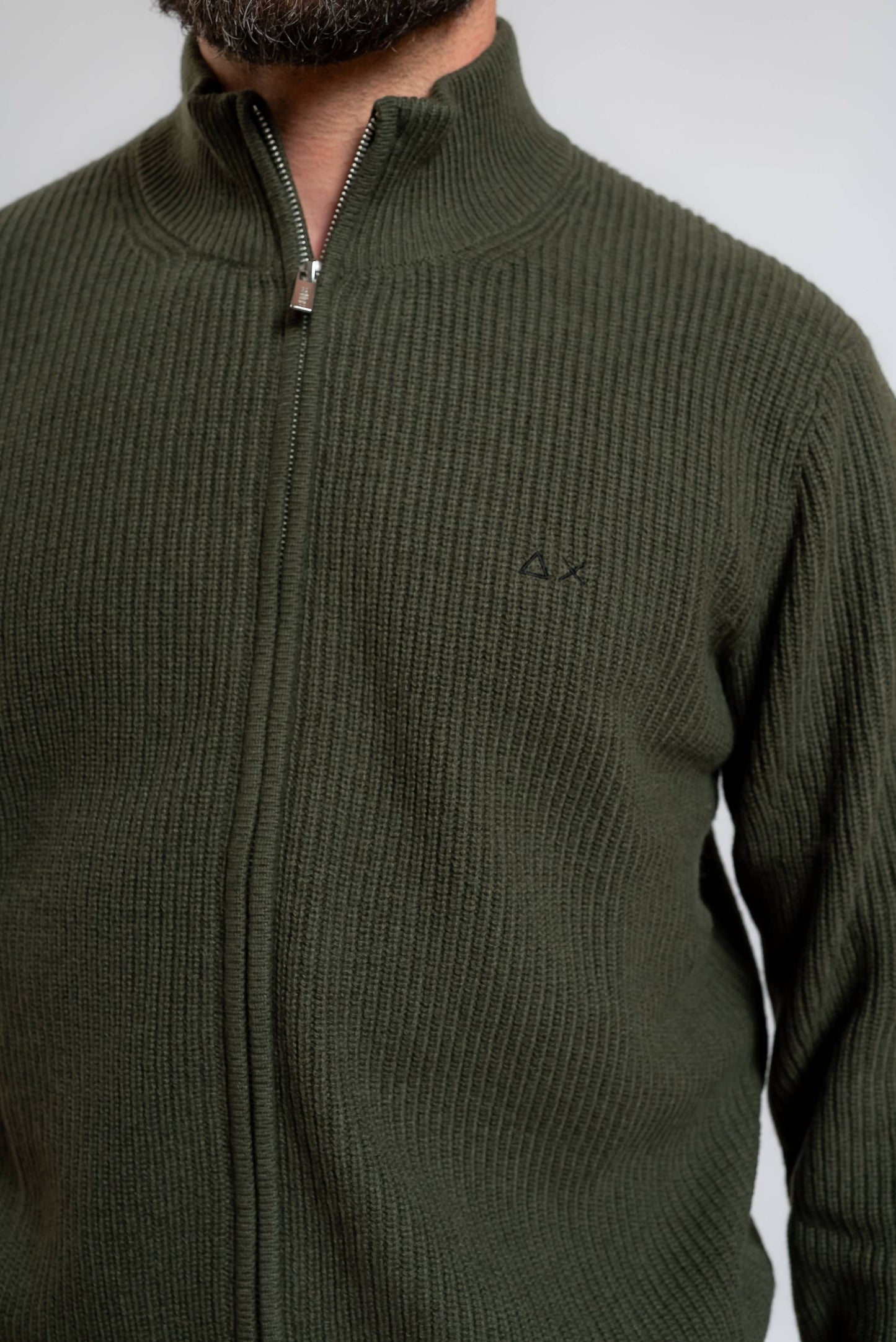 dettaglio del logo sun68 sul cardigan verde militare a costa inglese in misto lana merino e cashmere con collo alto e chiusura con zip 