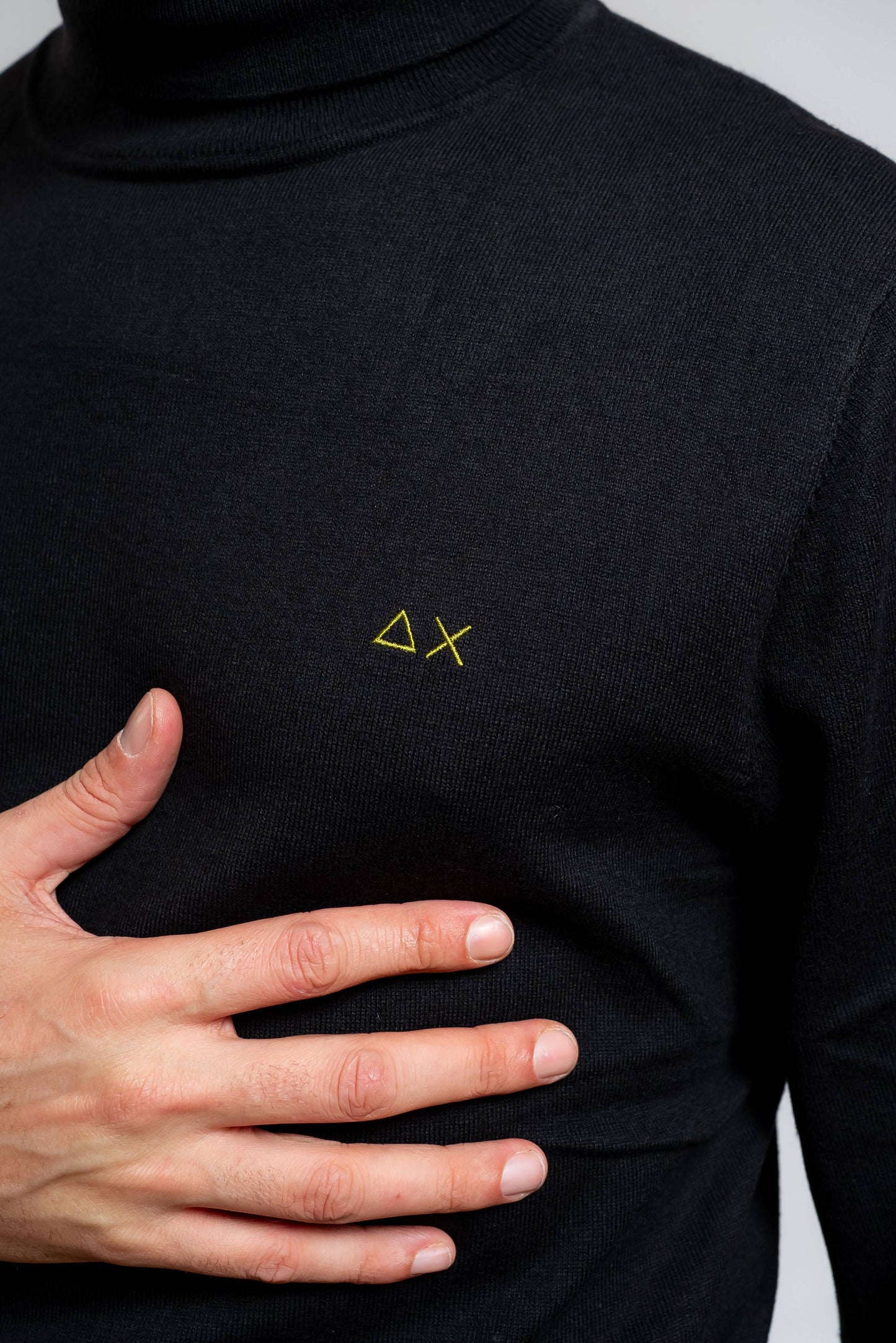 dettaglio del logo sun68 a contrasto giallo sul maglione a collo alto nero in cotone e lana merino