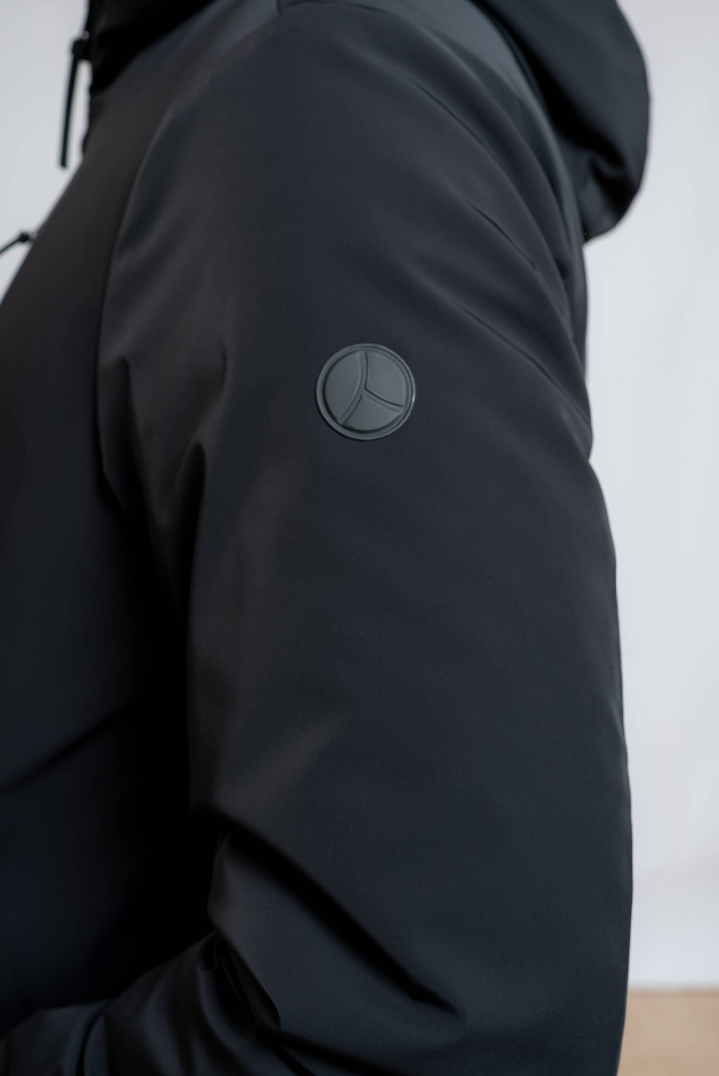 Dettaglio del logo people of shibuya sul giubbino Shikoku nero realizzato in tessuto tecnico da uomo