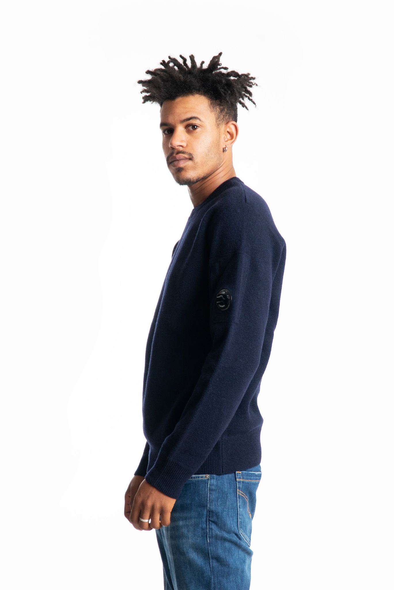 Maglione a girocollo in misto lana blu con lente cp company sulla manica, lato