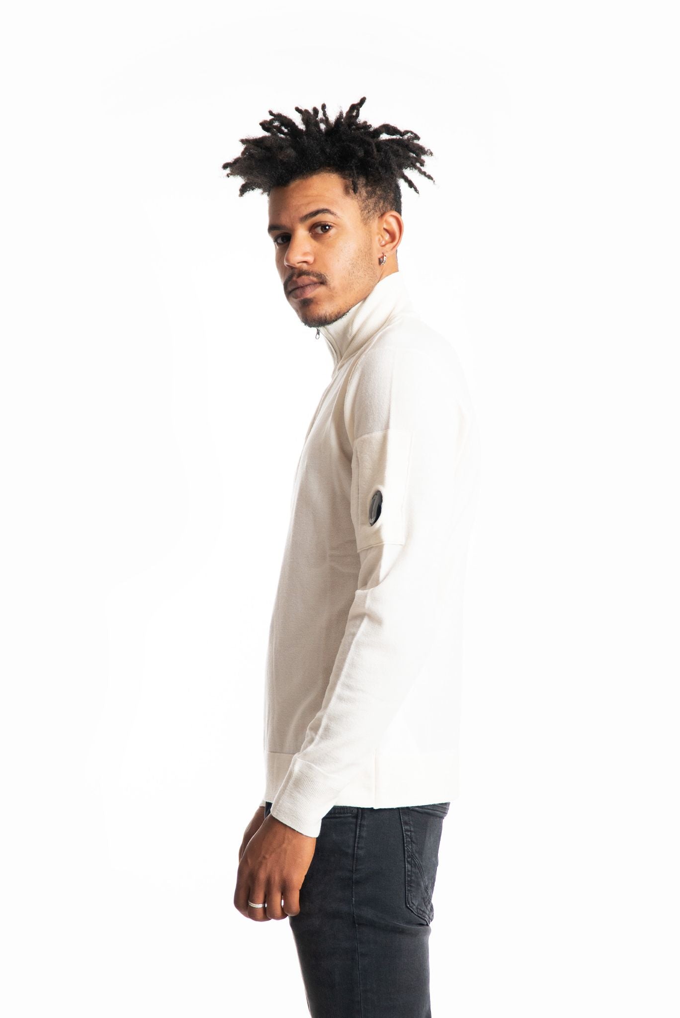 Maglia panna in misto lana con collo alto e mezza zip con lente cp company sulla manica polo collar, lato