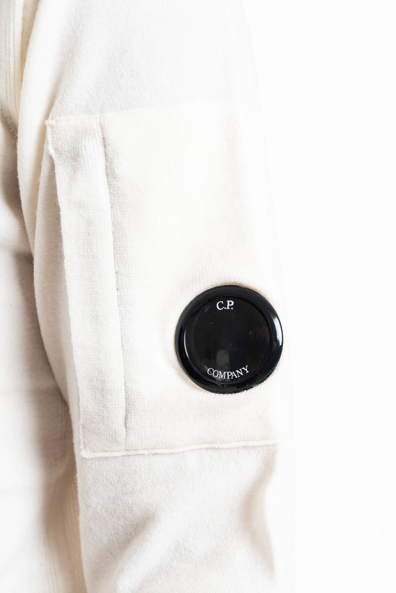 Maglia panna in misto lana con collo alto e mezza zip con lente cp company sulla manica polo collar, dettaglio